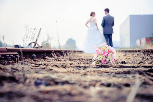 Couple nouvellement marié marchant sur les rails d'une paire de voies ferrées — Photo