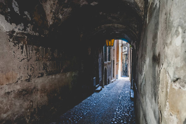 Covered arch passage in an old french medieval mountain village. An urban look with a beautiful old streetlight and arcades in a narrow alley