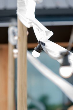 Ampulleri beyaz süs eşyaları ve bir plajda meşaleler ile bir tel üzerinde