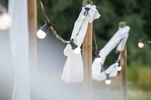Glühbirnen auf einem Draht mit weißen Ornamenten und Fackeln auf einem Schnabel — Stockfoto