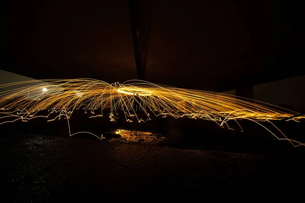 Light paint with spinning fire sparks that are jumping arround — Stock Photo, Image