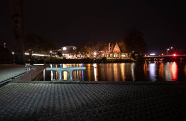 Aydınlatılmış şehir manzaralı Jetty yansıması ile gökyüzü