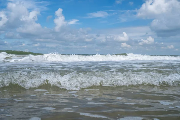 Spetterende golven aan de kust van Nederland met wit schuim — Stockfoto