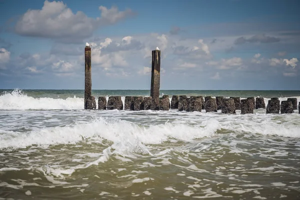Splashing waves of the North Sea on the wooden breakwaters of th — 스톡 사진