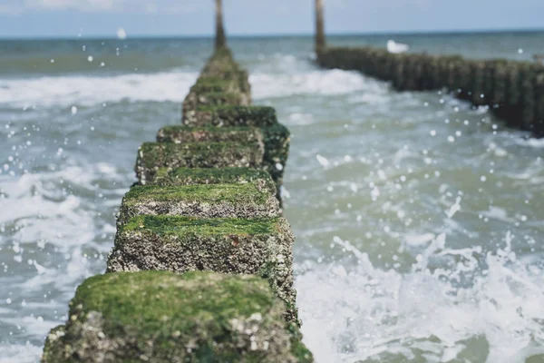 Közel strand oszlopok fröcskölt víz a tenger partján — Stock Fotó