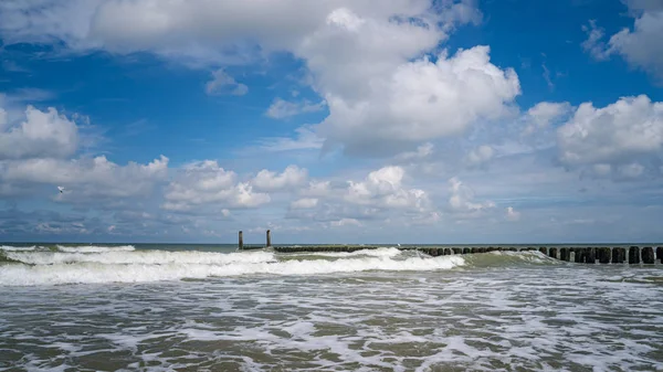 Salpicando las olas del Mar del Norte en los rompeolas de madera de th —  Fotos de Stock