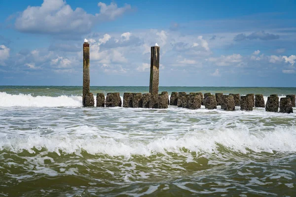 Spetterende golven van de Noordzee op de houten golfbrekers van th — Stockfoto