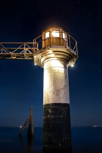 晴れた青い星空の下での夜の間の港や歴史的な航海灯塔 オランダのフリースラント州ローワースメール — ストック写真