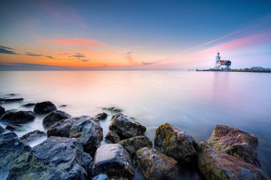 Güneş doğarken Marken Deniz Feneri Atı (Het Paard van Marken). Marken, Hollanda 'da IJsselmeer kıyısında küçük bir balıkçı köyüdür.
