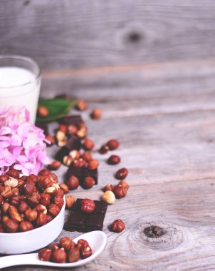 Taze fındık, süt ve ahşap zemin üzerine koyu çikolata