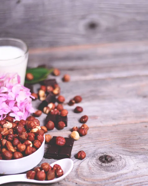 新鲜的榛子、 牛奶和黑巧克力木背景 — 图库照片