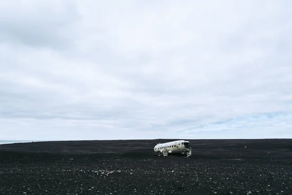 Avião destruído na praia de areia negra na Islândia. Paisagem islandesa atmosférica — Fotografia de Stock