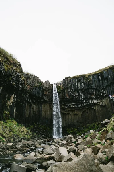 Potężny wodospad Svartifoss w Islandii pod szarym, pochmurnym niebem — Zdjęcie stockowe