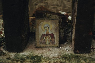 Tuğlaların altındaki yıpranmış Bakire Meryem ikonu yok edilmesini önlüyor. Lviv, Ukrayna yakınlarındaki eski kilisenin kalıntıları..