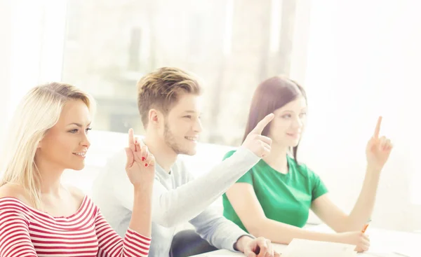 Groep studenten verhogen handen — Stockfoto