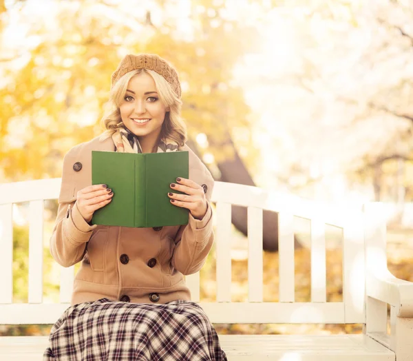 Woman sitting on bench with book — Stock Photo, Image