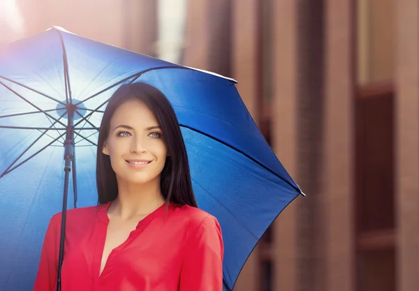 Молода і щаслива жінка під блакитною парасолькою — стокове фото