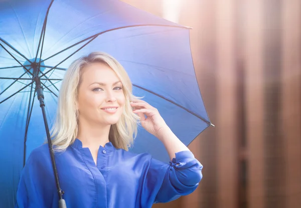 Young and happy woman under blue umbrella — Stock Photo, Image