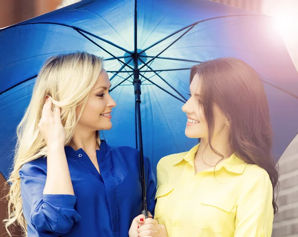 Young and happy women under blue umbrella — Stock Photo, Image