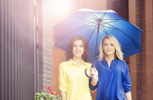 Young and happy women under blue umbrella — Stock Photo, Image