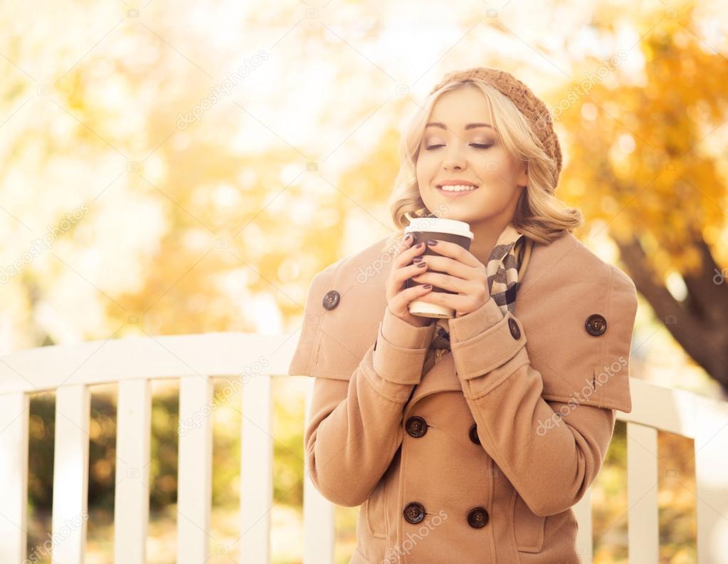 woman sitting on bench and drinking coffee