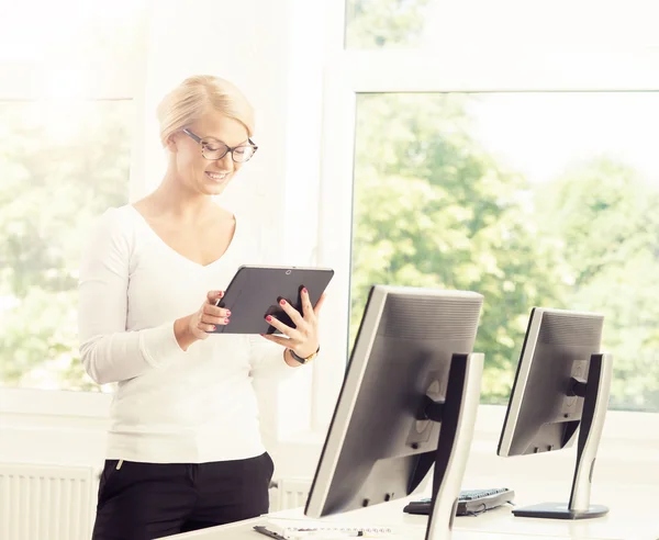 Beautiful blonde businesswoman standing in office — Stock Photo, Image