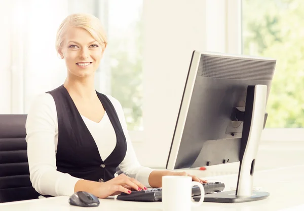 Piękne blond kobieta siedzi w biurze — Zdjęcie stockowe