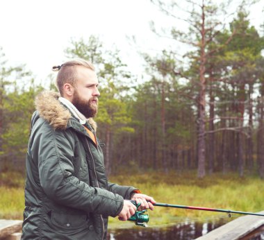 Balıkçılık iplik çubuk ile genç adam