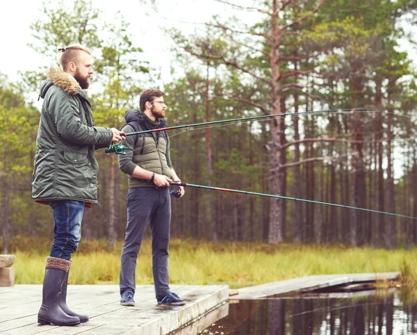 Hombres jóvenes pescando con cañas giratorias —  Fotos de Stock