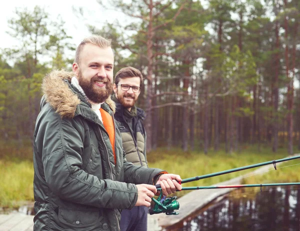 Молодые люди ловят рыбу с прутьями — стоковое фото