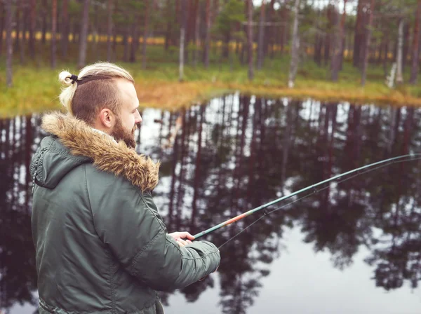 Jonge man visserij met spinnen staaf — Stockfoto