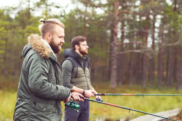 Молодые люди ловят рыбу с прутьями — стоковое фото