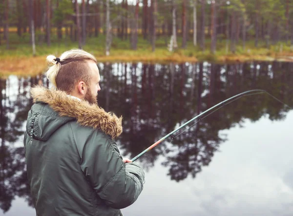 Jovem pesca com vara giratória — Fotografia de Stock