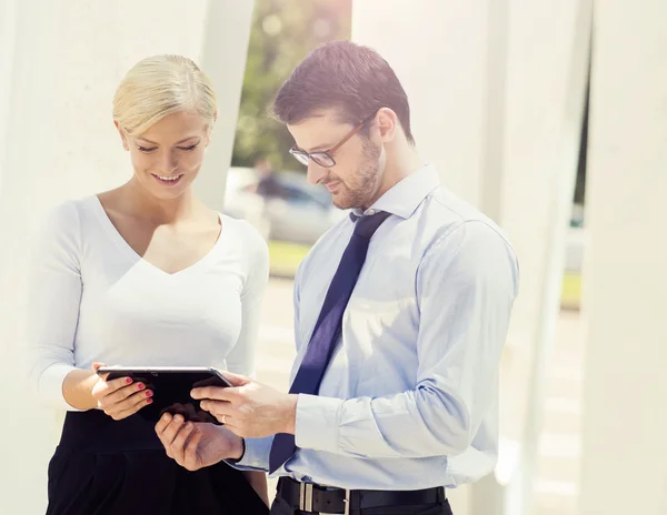 Bizneswoman i biznesmen patrząc cyfrowych tabletu — Zdjęcie stockowe