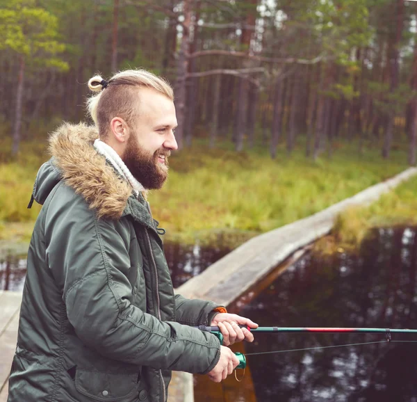 Jonge man visserij met spinnen staaf — Stockfoto