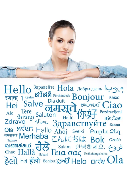 Žena za banner s slov různých jazyků — Stock fotografie