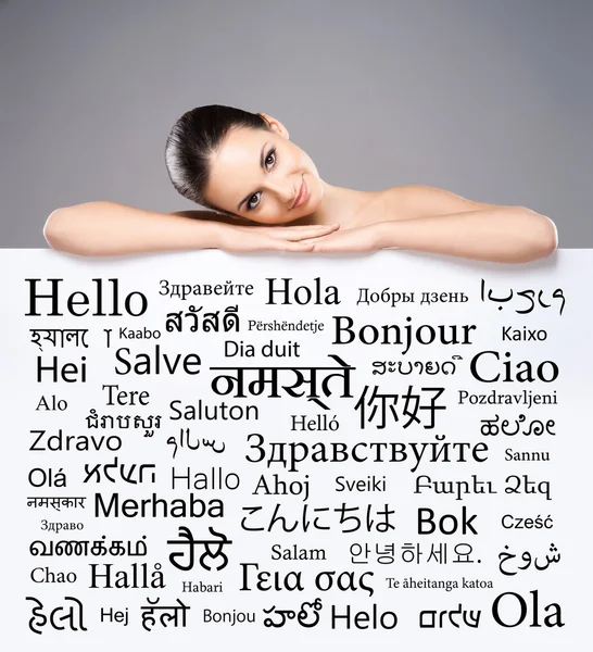Γυναίκα πίσω από πανό με λέξεις διαφορετικές γλώσσες — Φωτογραφία Αρχείου
