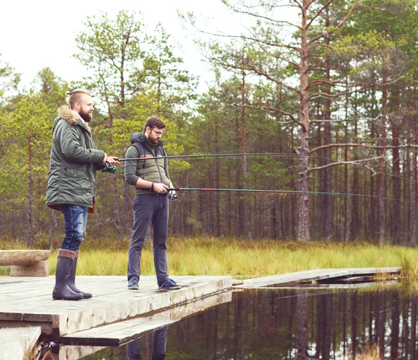 Homens jovens pesca com varas de fiação — Fotografia de Stock