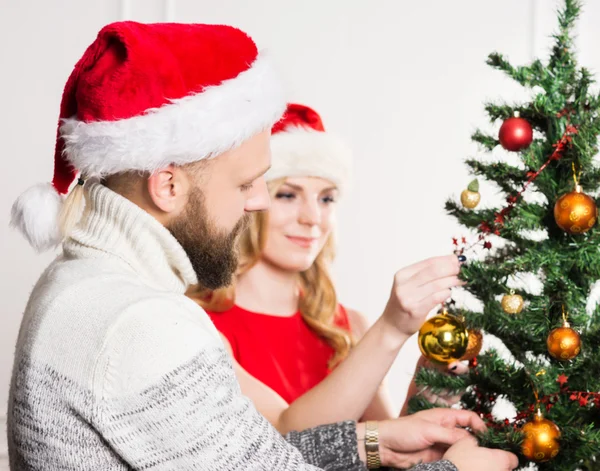Jeune couple heureux dans des chapeaux de Noël — Photo