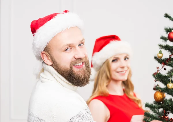 Young happy couple in Christmas hats — Stock Photo, Image