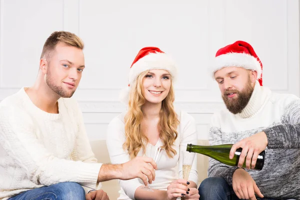 Groupe d'amis dans chapeaux de Noël célébrant — Photo