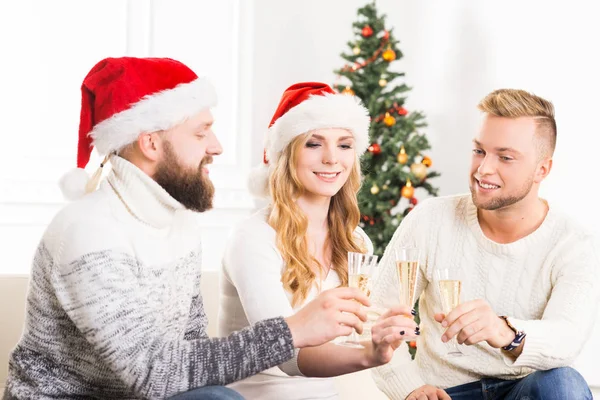 Group of friends in Christmas hats celebrating — Stock Photo, Image