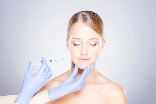 Läkare att göra injektion i ansiktet av kvinna — Stockfoto