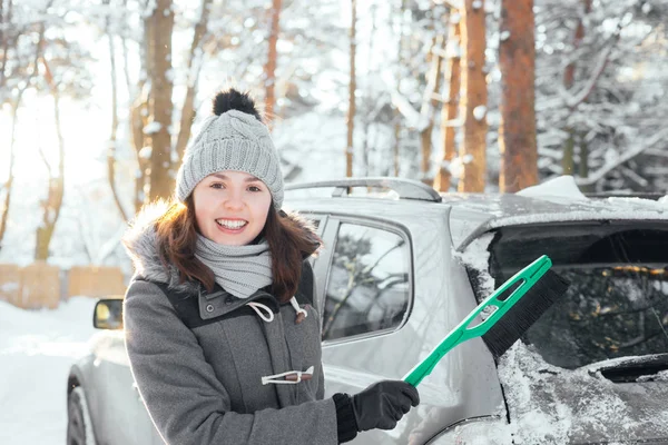 Jovem mulher limpando carro de neve — Fotografia de Stock