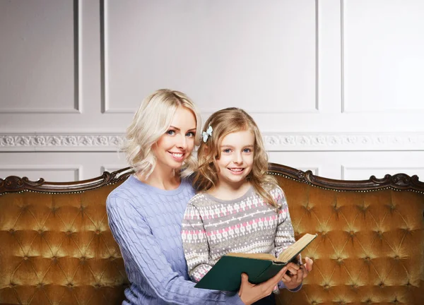 Mother and daughter reading book at home