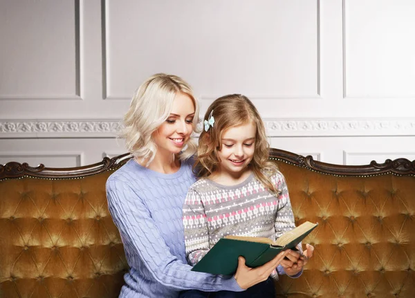 Anne ve kızı evde kitap okuyorlar. — Stok fotoğraf