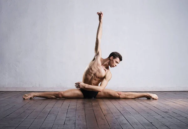 Handsome ballet dancer sitting on split — Stock Photo, Image