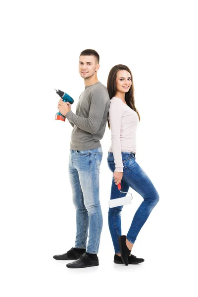 Young man and woman holding tools — Stock Photo, Image