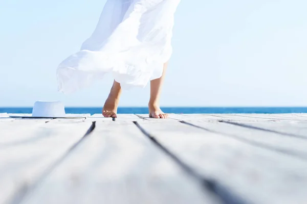 Vrouwelijke benen op houten pier — Stockfoto