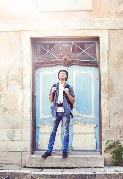 Man standing against old blue door — Stock Photo, Image